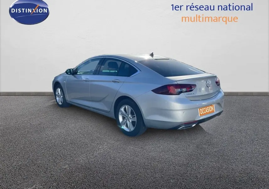 Opel Insignia gris minéral métal vue 3/4 arrière droit, berline 5 portes avec jantes alliage et feux LED.