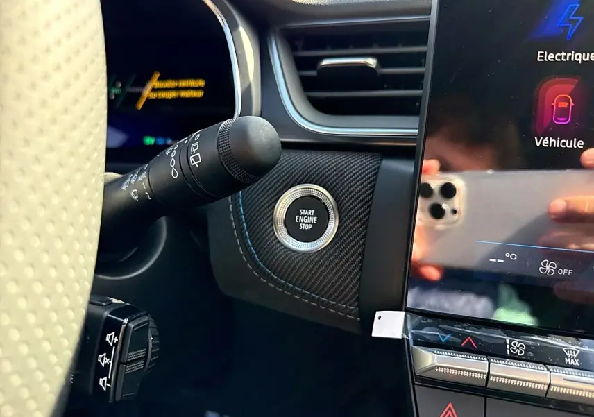 Gros plan intérieur côté gauche sur le bouton Start Engine Stop et écran tactile du Renault Symbioz gris rafale.