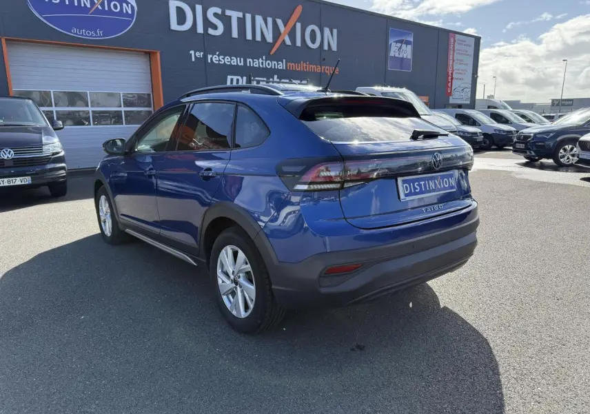 Volkswagen Taigo bleu récif métallisé vu en 3/4 arrière droit, avec feux arrière LED et toit noir contrasté.