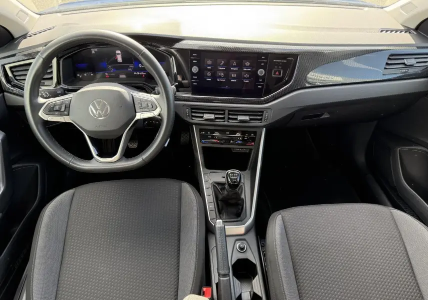 Intérieur du Volkswagen Taigo 2024 avec tableau de bord moderne, volant cuir multifonctions et boîte manuelle centrale.
