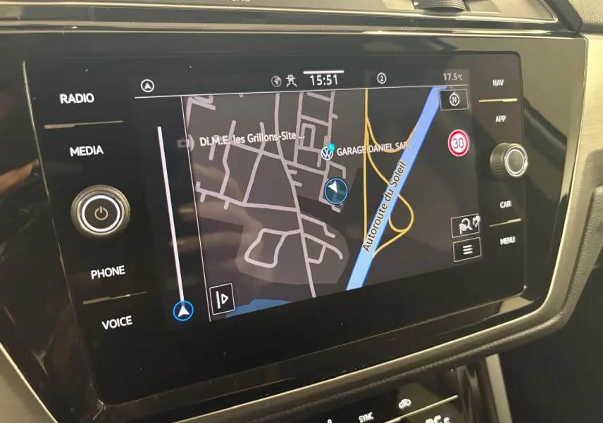 Écran tactile du système de navigation du Volkswagen Touran 2024 affichant une carte avec options multimédia et climatisation.
