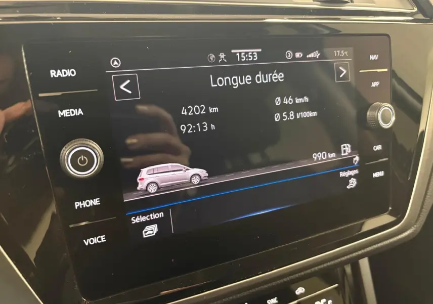 Écran tactile central du Volkswagen Touran 2024 affichant les données de conduite longue durée en intérieur noir.