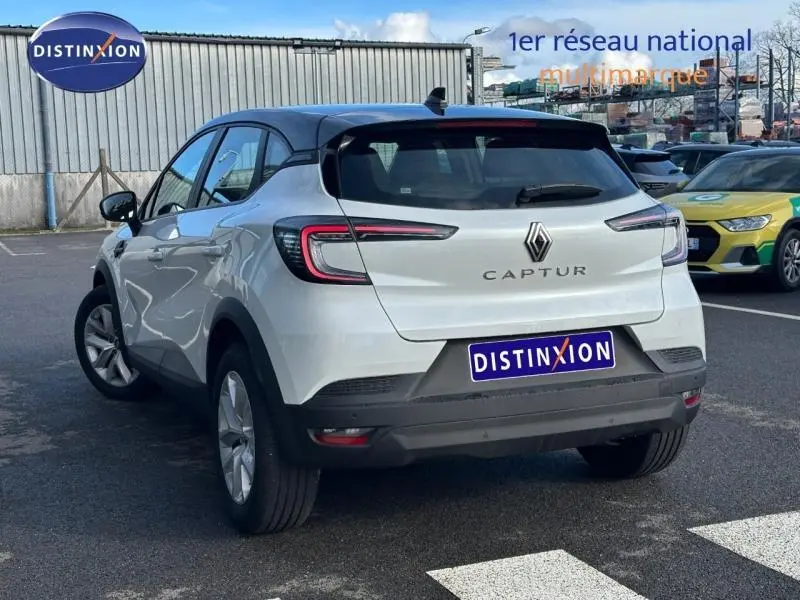 Vue 3/4 arrière droite d'un Renault Captur blanc nacré avec toit noir et feux arrière LED distinctifs.