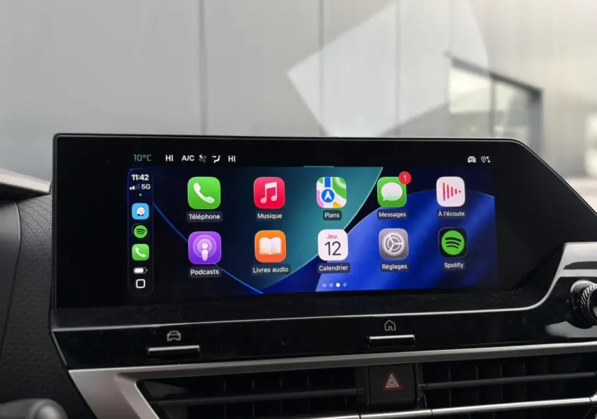 Écran tactile central affichant Apple CarPlay dans l'habitacle du Citroën C4 Hybrid gris Mercury, vue de face.