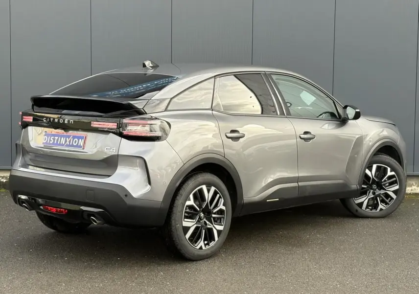 Vue 3/4 arrière droite d'une Citroën C4 gris Mercury avec jantes alliage et toit noir brillant.