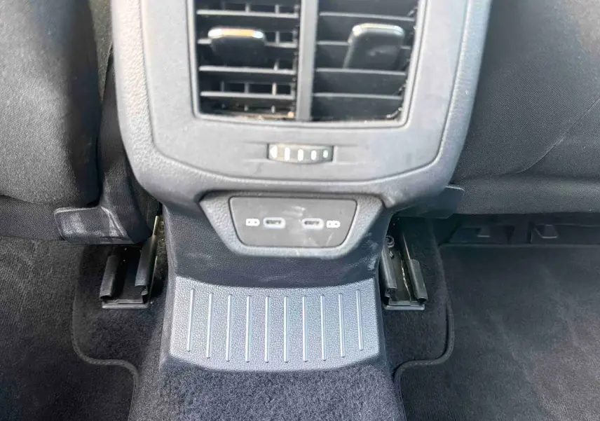Vue intérieure centrée sur la console arrière noire du Volkswagen T-Roc 2025 avec prises USB et aérateurs.