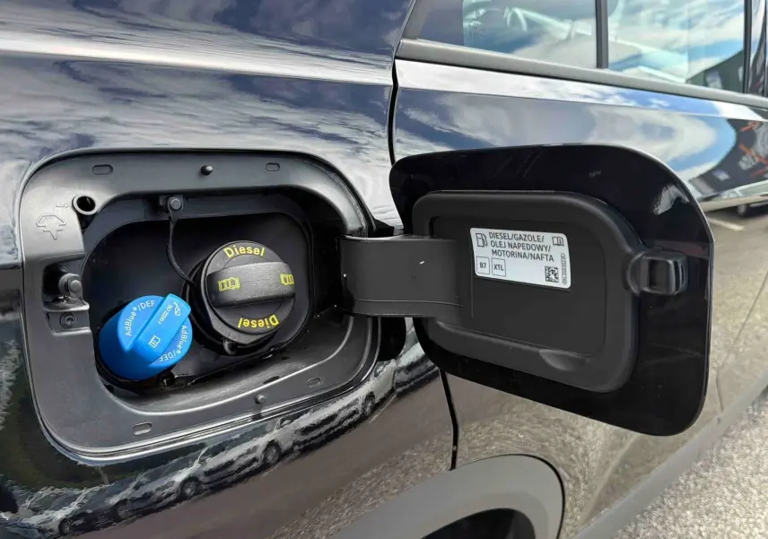 Vue rapprochée de la trappe à carburant ouverte côté gauche d’un Volkswagen T-Roc noir diesel.
