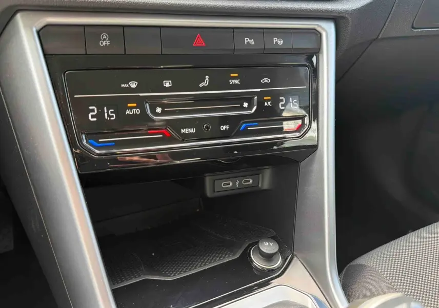 Détail de la console centrale du Volkswagen T-Roc 2025 avec climatisation automatique bi-zone et ports USB visibles.