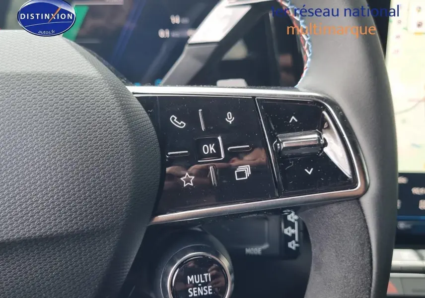 Gros plan sur les commandes multifonctions du volant noir du Renault Austral 2025 version hybride en bleu iron.
