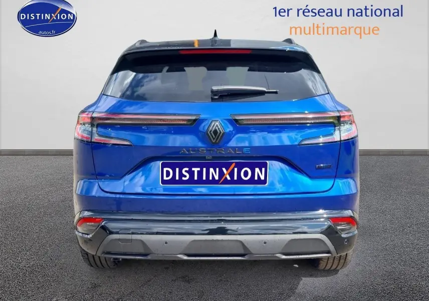 Vue arrière d'un Renault Austral bleu iron avec feux LED étirés et hayon motorisé, sur fond neutre.