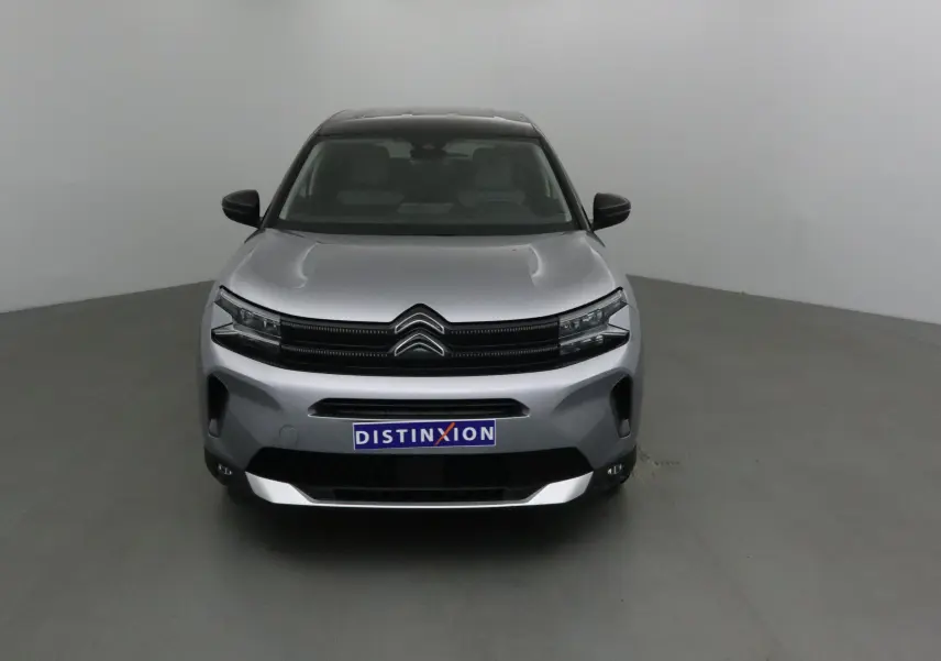 Vue frontale d'un Citroën C5 Aircross gris Artense avec toit noir, mettant en valeur sa calandre distinctive et ses phares LED.