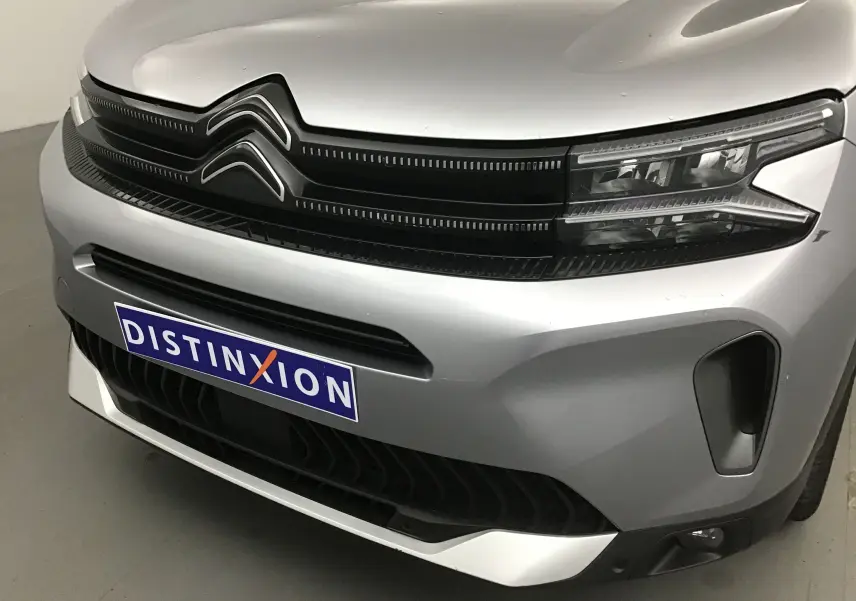 Gros plan sur l'avant gris Artense du Citroën C5 Aircross 2024 avec calandre noire et phares LED distinctifs.