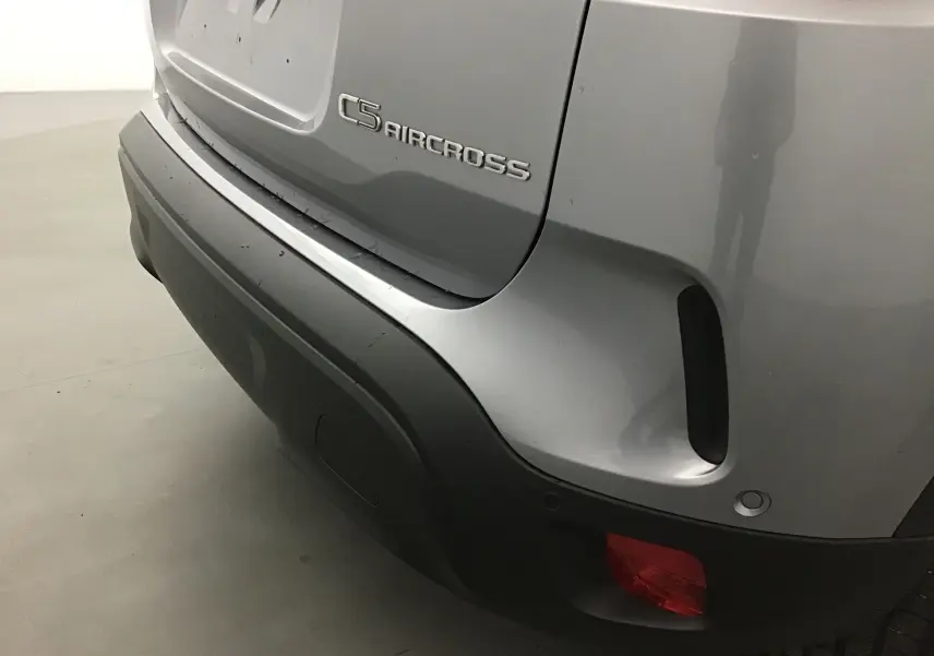 Gros plan sur le coin arrière droit gris Artense du Citroën C5 Aircross avec logo et feu antibrouillard rouge.