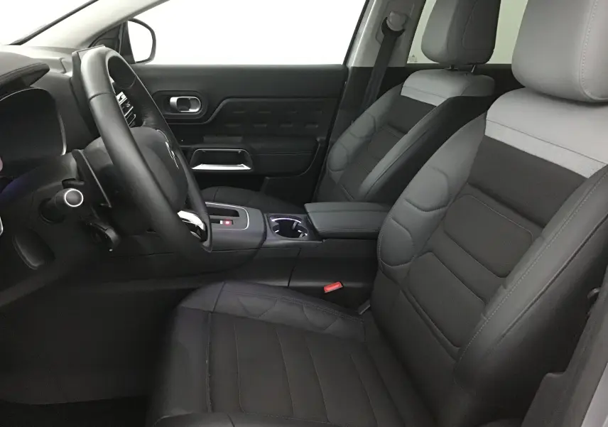 Vue intérieure côté conducteur du Citroën C5 Aircross 2024 avec sièges en cuir gris et console centrale moderne.