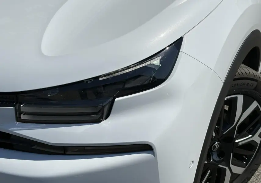 Gros plan sur l'avant droit blanc Okénite du Citroën C4 Hybrid 2025 avec phares LED et jante alliage 18 pouces.