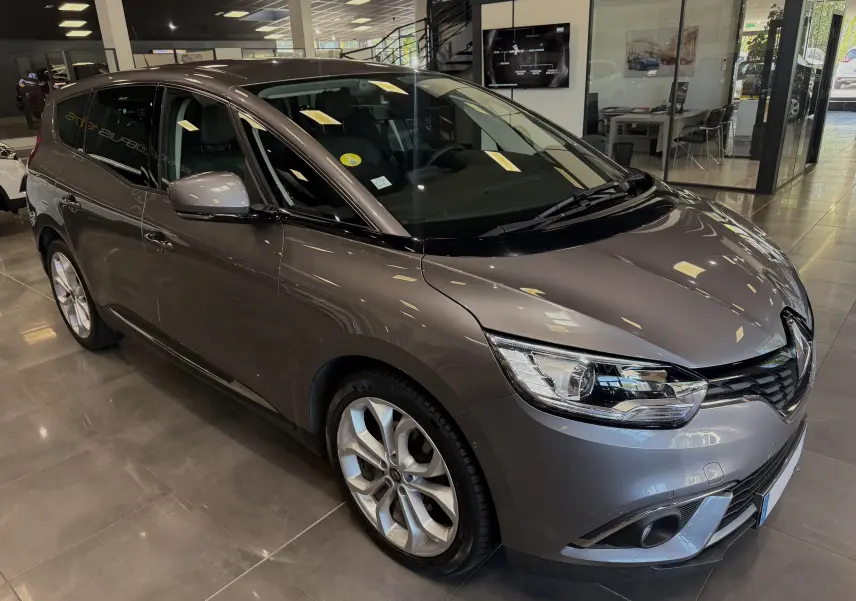 Renault Grand Scenic IV Business gris Cassiopée en 3/4 avant droit, avec jantes alliage et phares LED visibles.