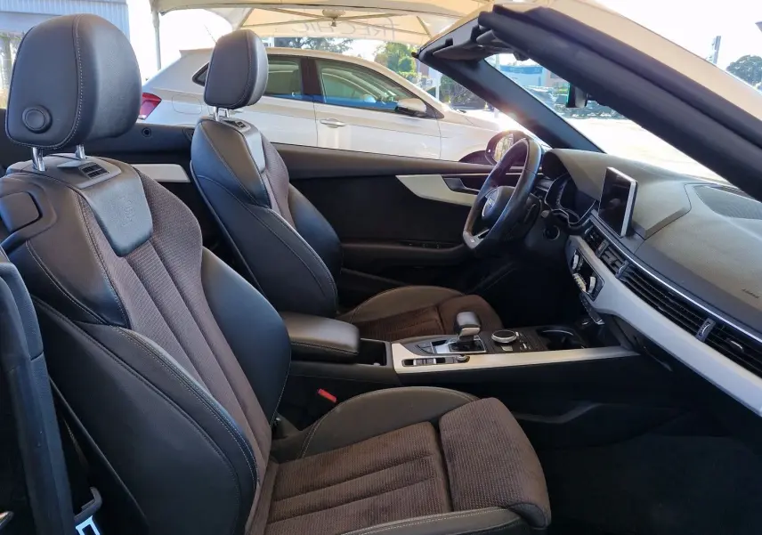 Intérieur noir de l'Audi A5 Cabriolet 2017 vu côté gauche, sièges sport en cuir et tissu avec tableau de bord moderne.