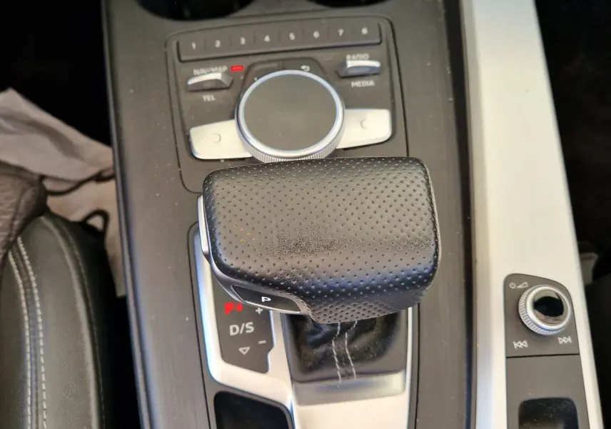 Vue rapprochée de la console centrale noire de l'Audi A5 Cabriolet 2017, mettant en valeur le levier de vitesse automatique en cuir perforé.