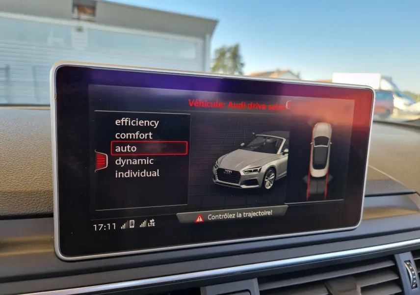 Écran multimédia affichant les modes de conduite d'une Audi A5 Cabriolet noir, vue intérieure du tableau de bord.