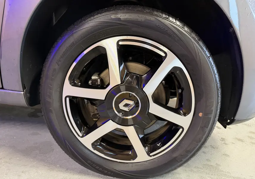 Gros plan sur la roue avant gauche grise d'une Renault Twingo III 1.0 TCE 90 Intens avec jante alliage noire et argent.