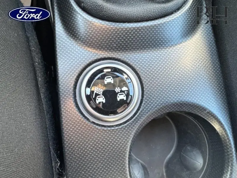 Gros plan sur le bouton de sélection de mode de conduite dans l'habitacle d'une FIAT 500X argentée.