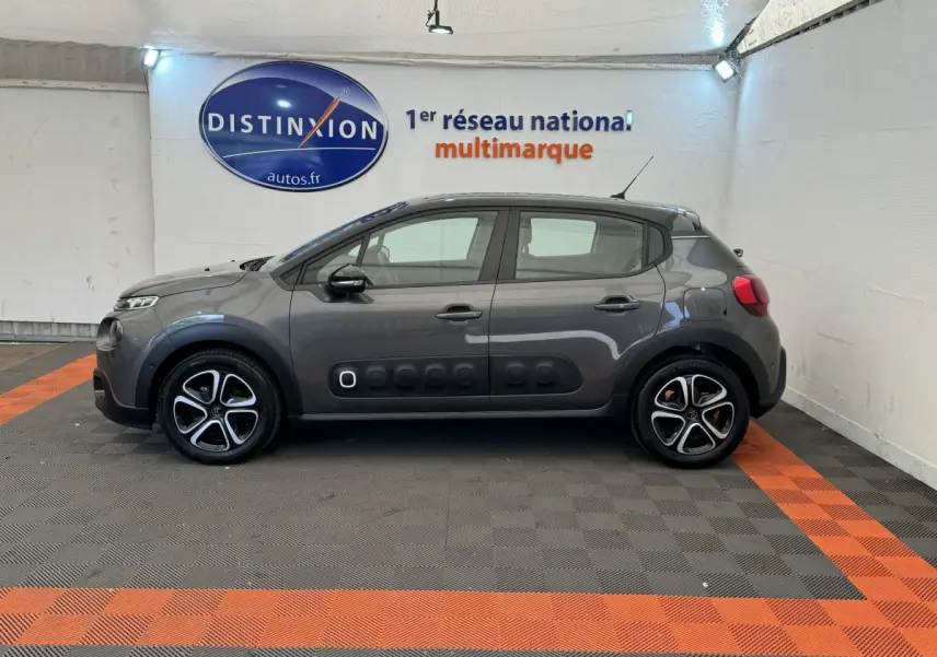 Profil côté gauche d'une Citroën C3 gris foncé 2020 avec protections latérales noires et jantes stylisées.