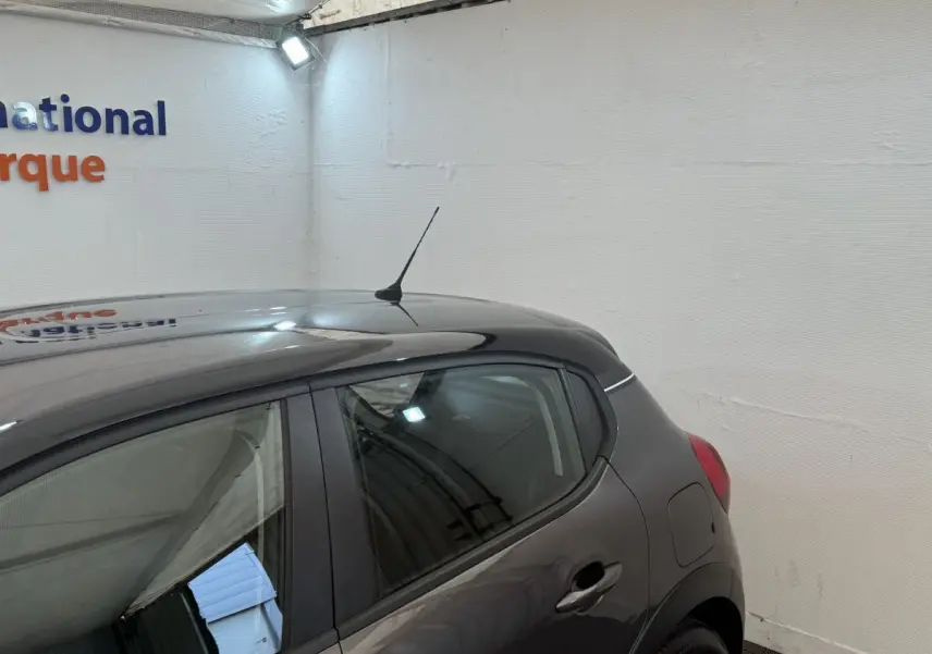 Vue côté droit arrière d'une Citroën C3 gris foncé, montrant la porte arrière et l'antenne de toit.