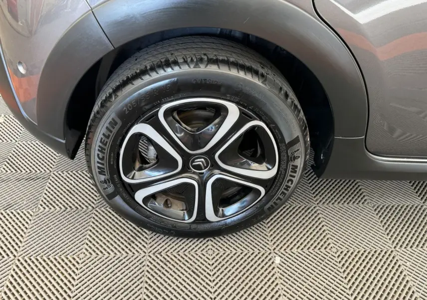 Gros plan sur la roue avant droite d'une Citroën C3 gris foncé avec jante alliage au design moderne.