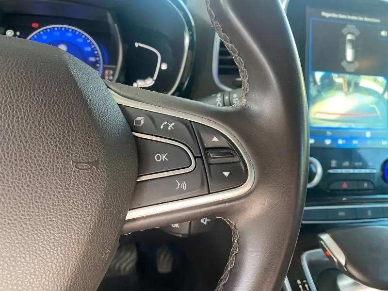 Gros plan sur le volant cuir noir du Renault Espace V 2018, avec commandes multifonctions et écran tactile affichant la caméra de recul.