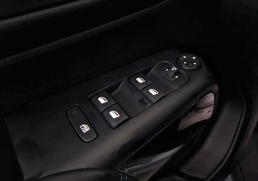 Gros plan sur les commandes de lève-vitres côté gauche du Citroën C5 Aircross gris 2024 avec finition noire intérieure.