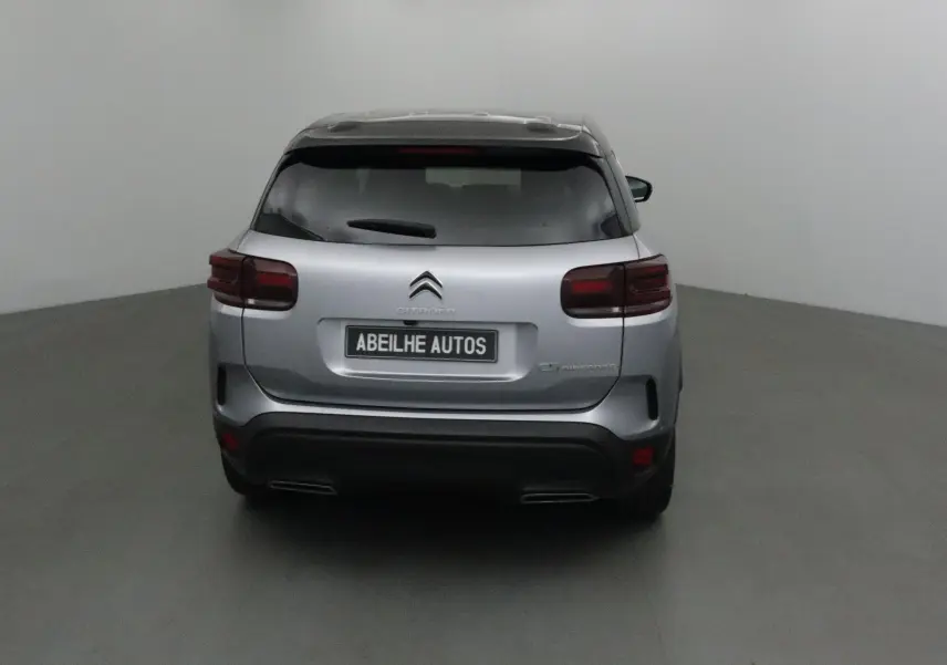 Vue arrière d'un Citroën C5 Aircross gris Artense avec toit noir, feux arrière foncés et double sortie d'échappement.