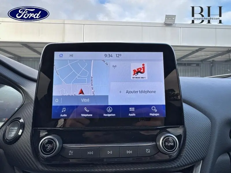 Écran tactile central du tableau de bord du Ford Puma blanc, affichant la navigation et les options multimédia.