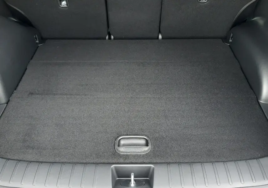 Vue intérieure du coffre du Hyundai Tucson 2025 gris Ecotronic, montrant le hayon électrique ouvert et l'espace de chargement vide.