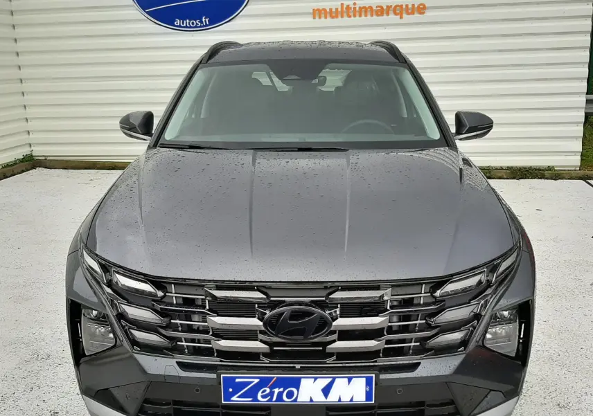Vue de face du Hyundai Tucson 2025 gris Ecotronic, mettant en valeur sa calandre chromée et ses phares LED distinctifs.