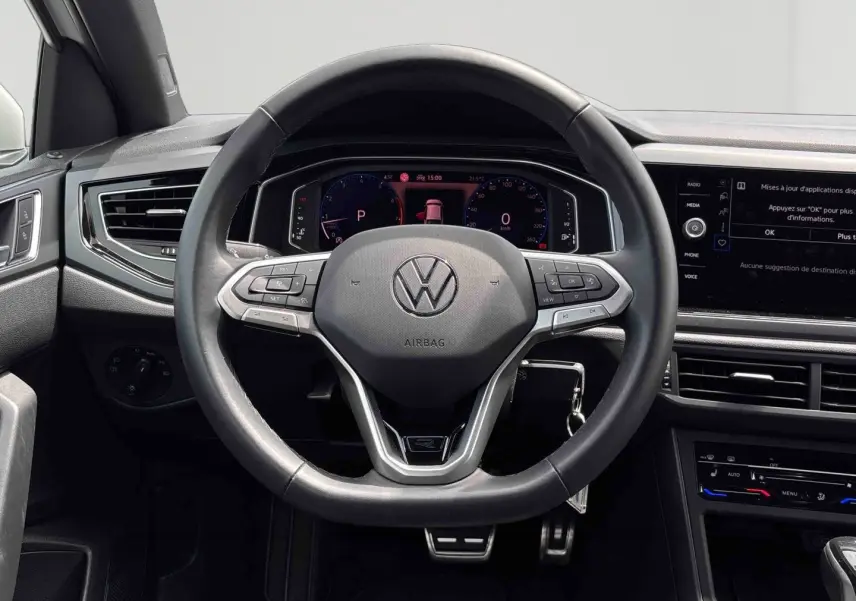Vue frontale du volant cuir multifonctions du Volkswagen Taigo blanc, avec tableau de bord digital et écran tactile central.