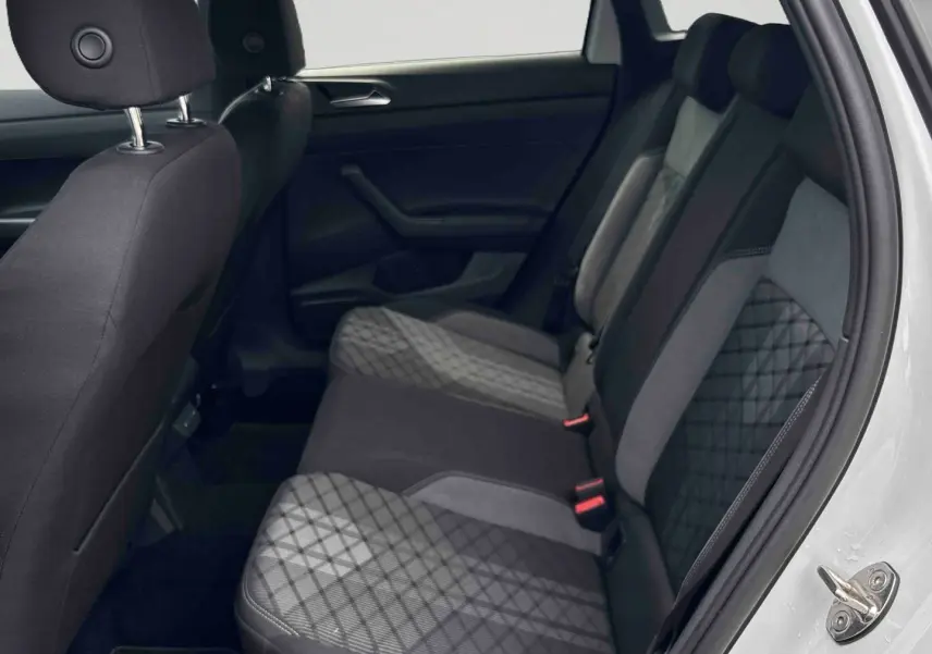 Vue intérieure côté droit des sièges arrière en tissu gris et noir du Volkswagen Taigo blanc, avec porte ouverte.