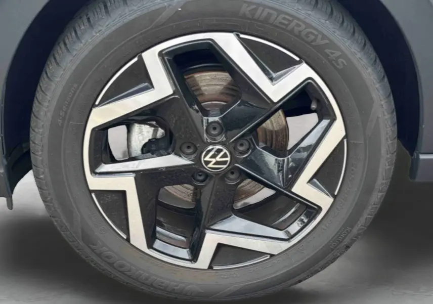 Gros plan sur la jante alliage noir et argentée 17 pouces du Volkswagen Taigo blanc, avec logo VW au centre.