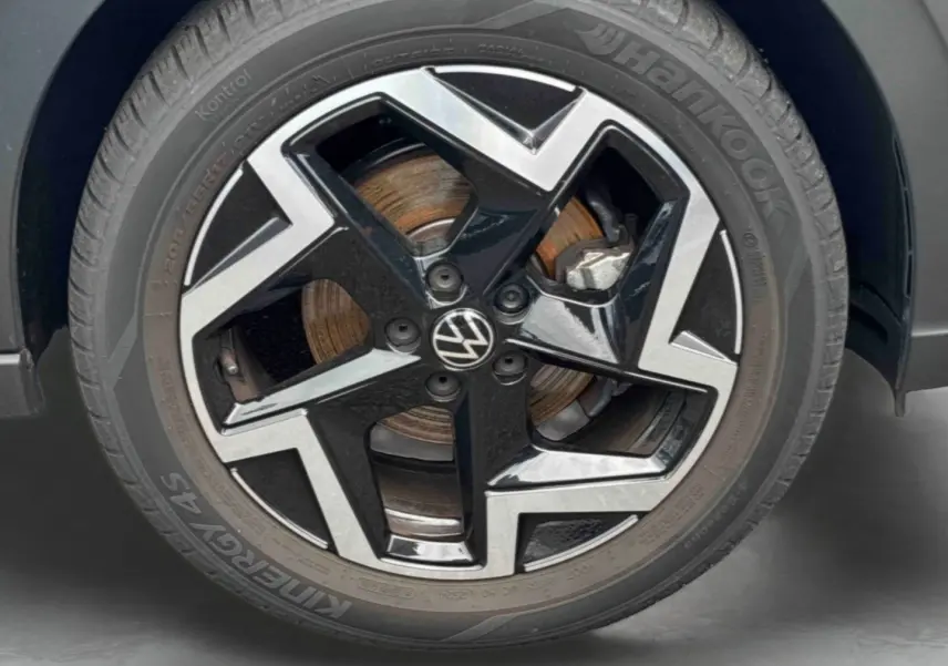 Gros plan sur la jante alliage noir et argentée de Volkswagen Taigo avec logo VW au centre et pneu Hankook.