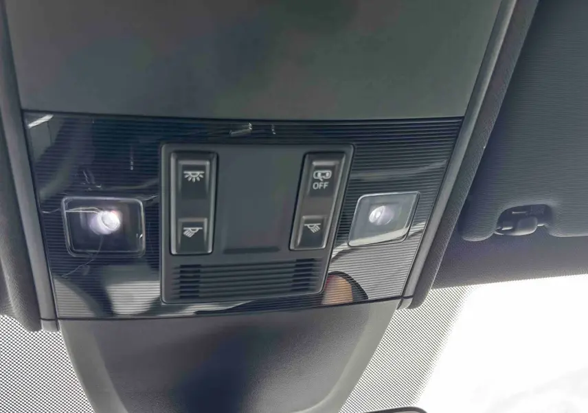 Vue en contre-plongée du plafonnier noir du Volkswagen Taigo 2025 avec commandes d’éclairage intégrées.