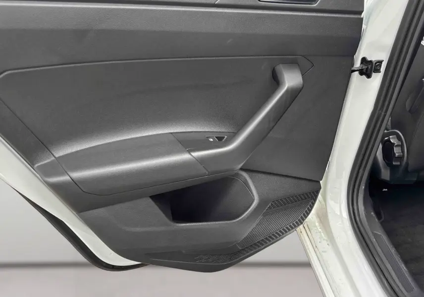 Vue rapprochée de la porte arrière gauche noire ouverte d’un Volkswagen Taigo blanc 2025.