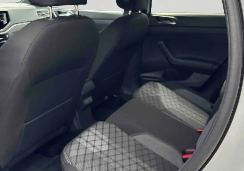 Vue intérieure arrière côté droit du Volkswagen Taigo blanc, sièges arrière avec tissu à motifs géométriques gris et noirs.