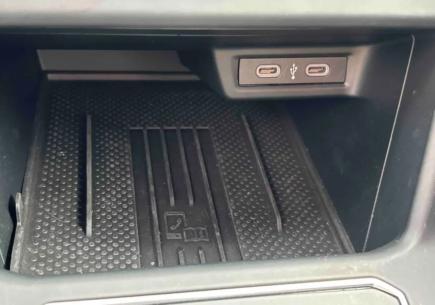 Gros plan sur la zone de chargement avec deux ports USB-C dans l’habitacle du Volkswagen Taigo blanc.