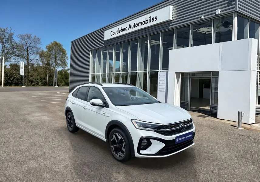 Volkswagen Taigo blanc en 3/4 avant droit, avec jantes alliage noires et logo R-Line visible sur ailes.