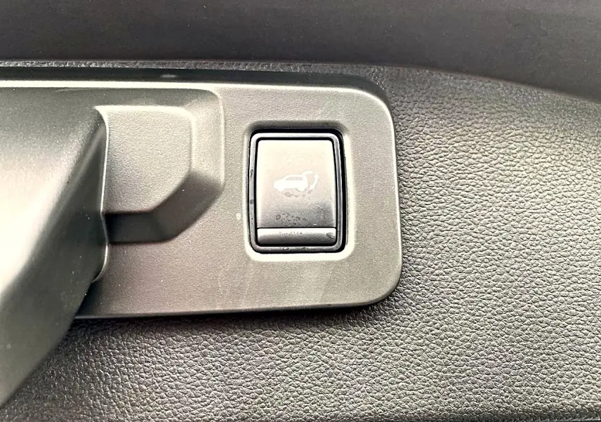 Bouton d'ouverture électrique du coffre sur panneau intérieur noir du Renault Austral gris schiste 2026.