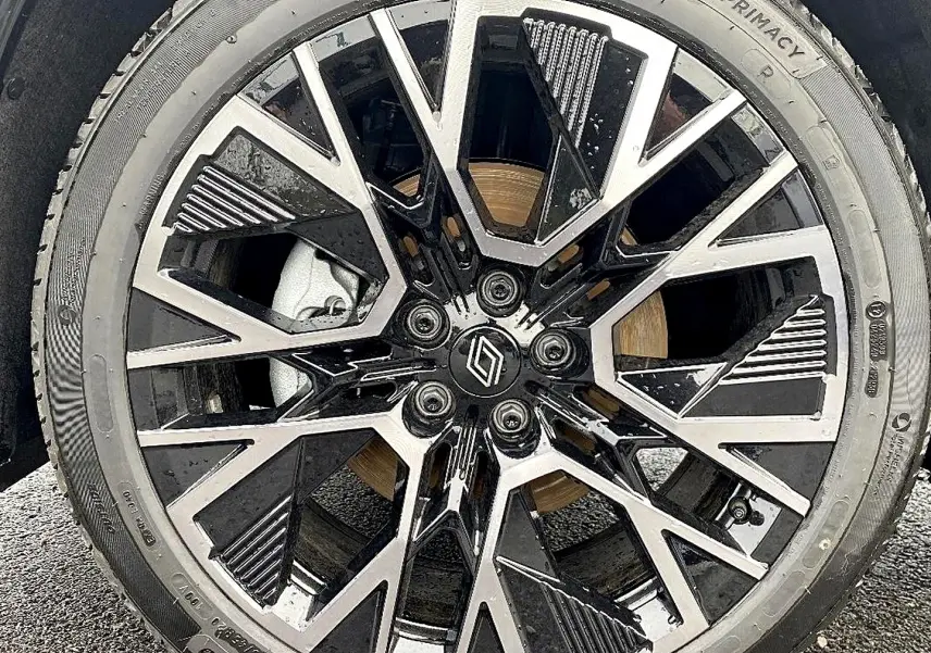 Gros plan sur la jante alu bicolore noire et argentée du Renault Austral gris schiste, avec logo Renault central.