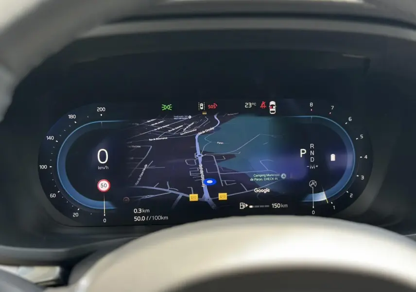 Vue rapprochée du tableau de bord numérique de la Volvo S60 rouge Fusion, affichant la navigation GPS et les indicateurs de vitesse.