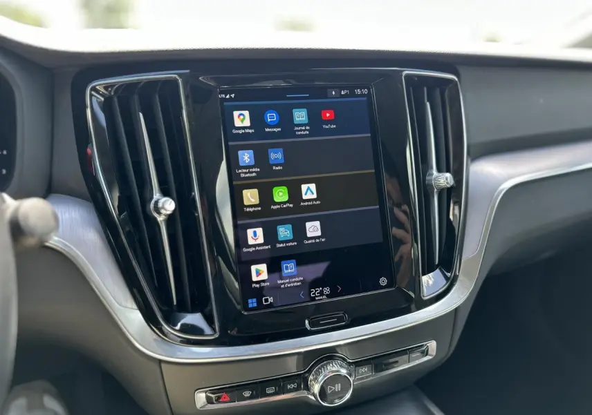 Écran tactile central du tableau de bord du Volvo S60 rouge Fusion 2024 avec commandes multimédia visibles.