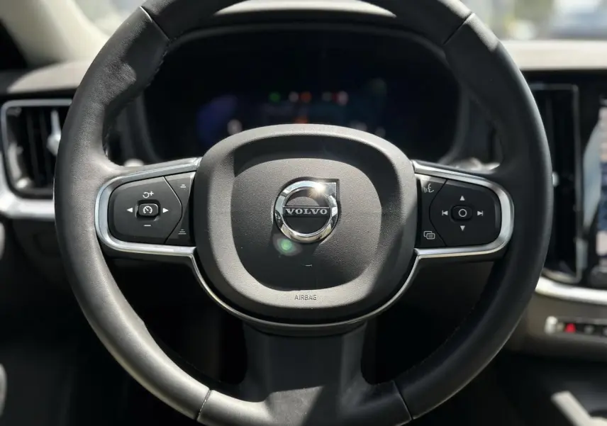 Volant noir de Volvo S60 2024 B4 Core+ avec commandes intégrées, vue frontale centrée sur le volant.