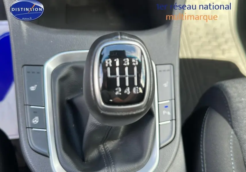 Gros plan sur le levier de vitesses manuel d'une Hyundai i30 SW gris clair, entouré de commandes de sièges chauffants.