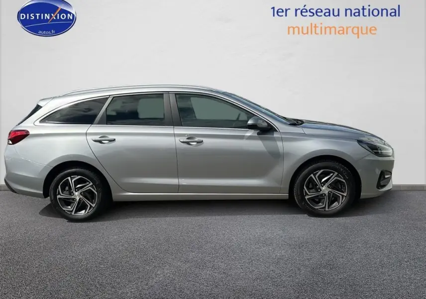Profil côté gauche d'une Hyundai i30 SW gris clair 2022 avec jantes alliage 17 pouces et vitres surteintées.
